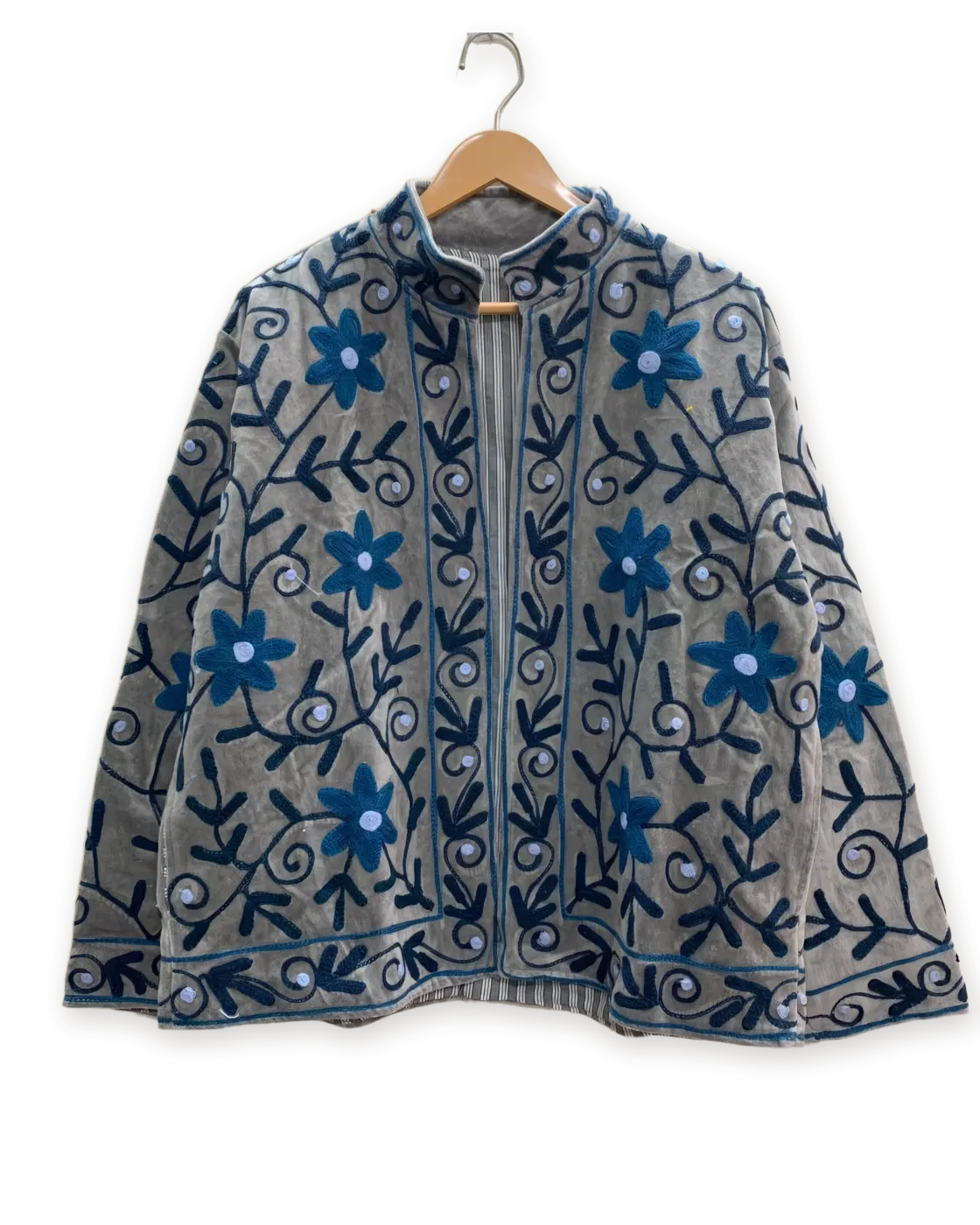 Chaqueta Ceniza y azul, bordada a mano, colgada en su percha