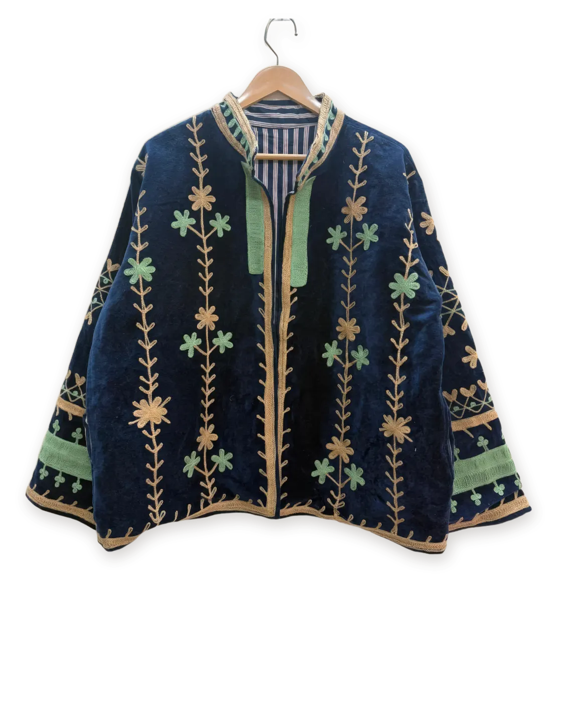 Chaqueta Marino y salvia, bordada a mano, colgada en su percha